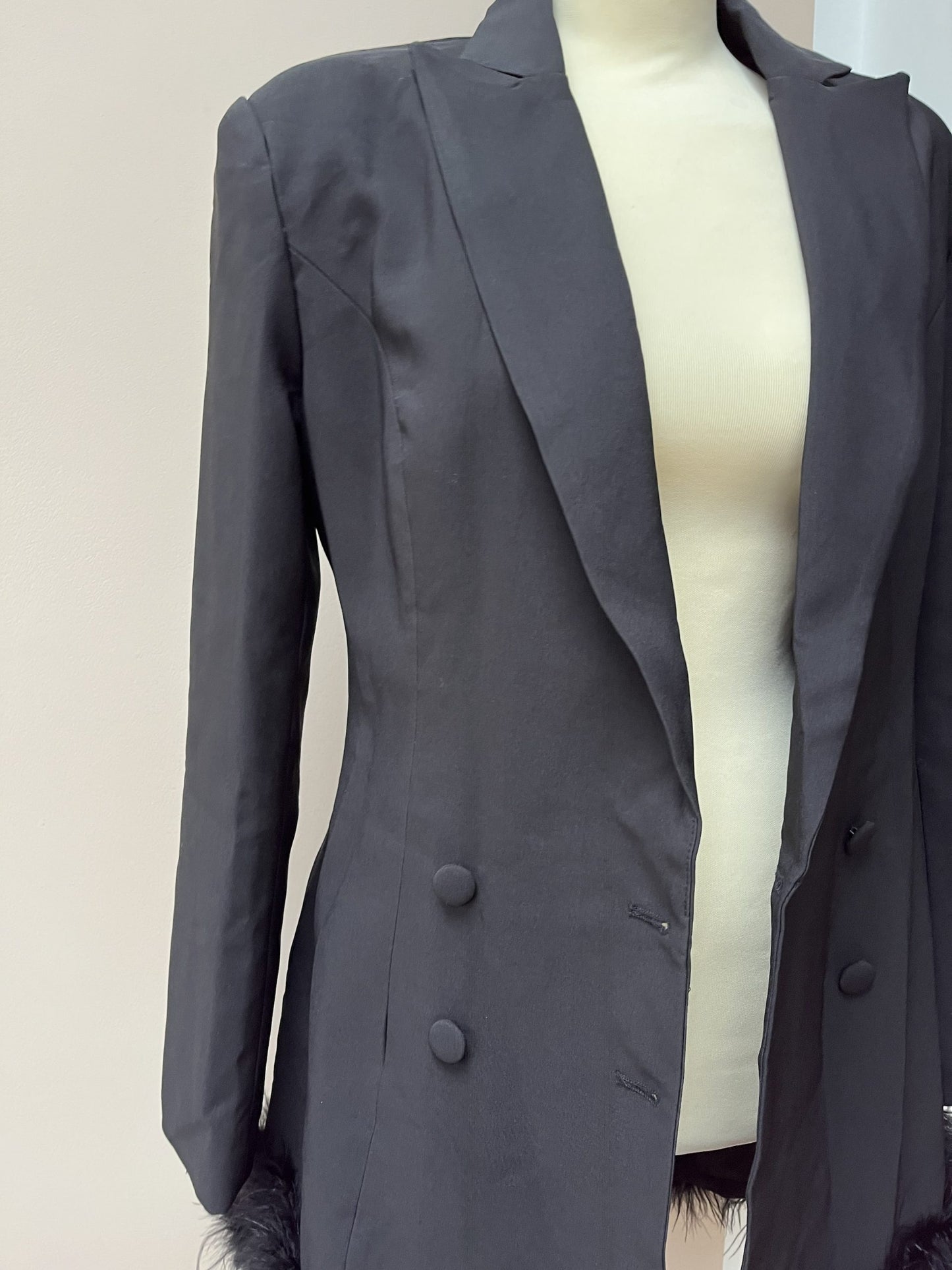 Black tuxedo style dress or jacket with feather hem. Size 12