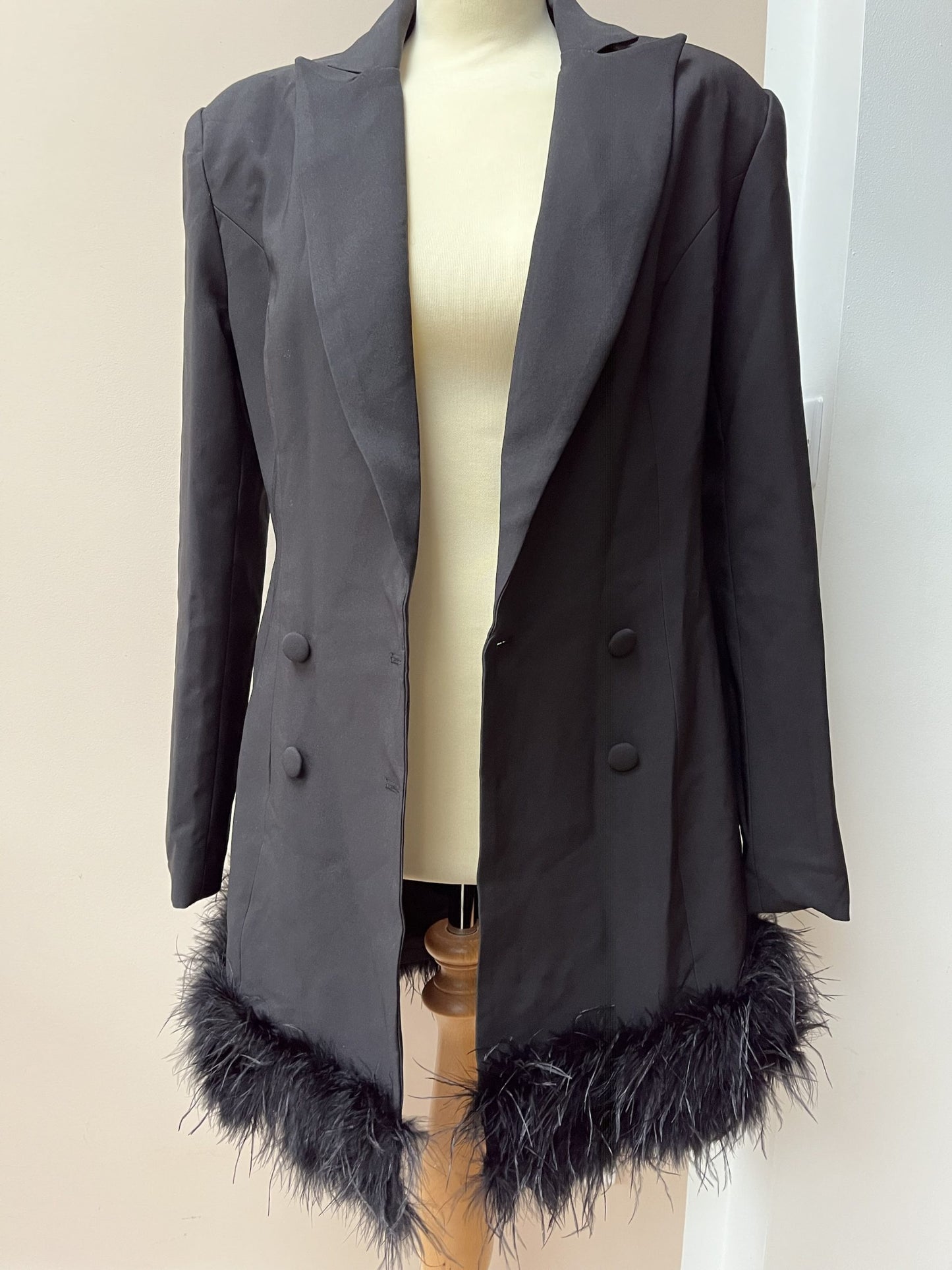 Black tuxedo style dress or jacket with feather hem. Size 12