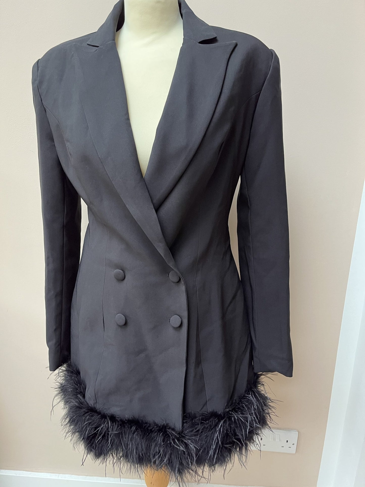 Black tuxedo style dress or jacket with feather hem. Size 12