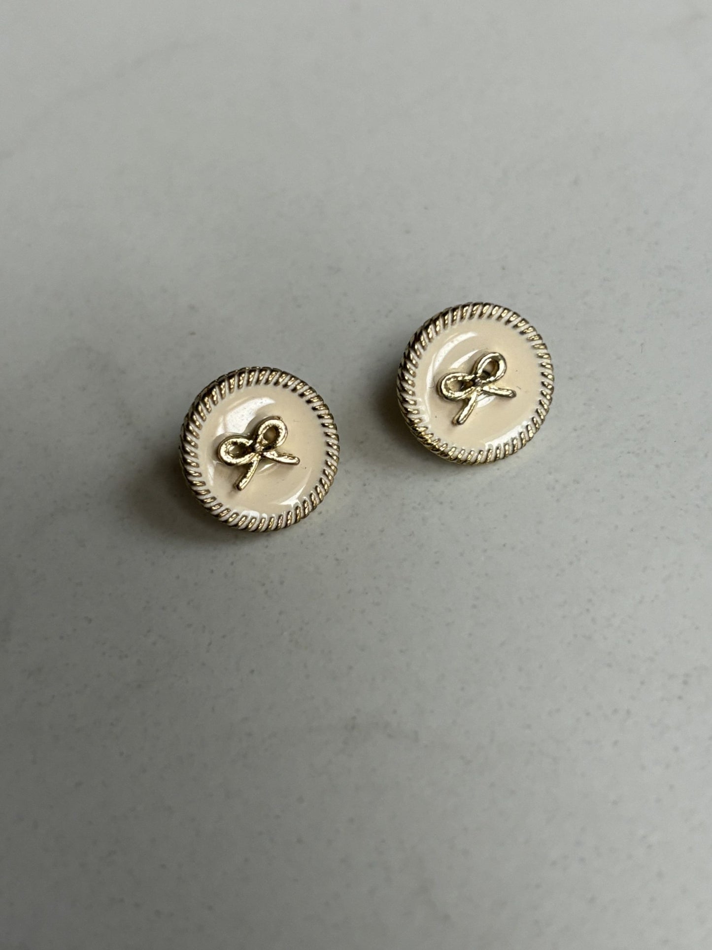 Gold bow and pale pink stud earrings